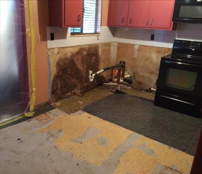 a kitchen with walls discolored and flooring taken out