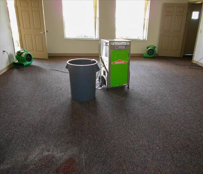room with carpet and servpro equipment