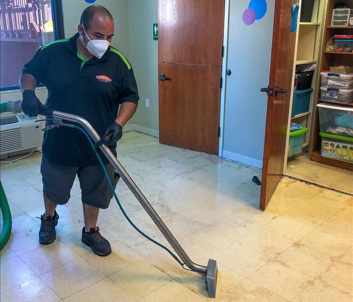 SERVPRO technician removing water from the floor of a Lakeland, FL business
